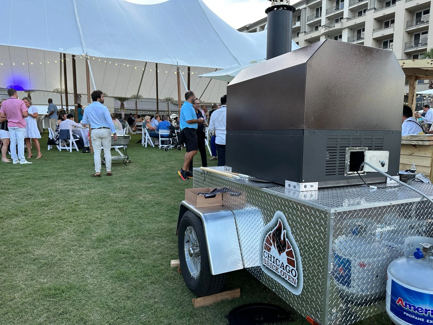 Outdoor event with CBO 750 Tailgater Pizza Oven, people in the background