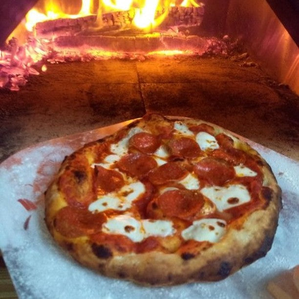 Pizza from CBO-750 tailgater pizza oven, showing fire inside