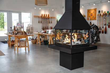 Modern matte black freestanding Don bar 9200 series fireplace in a room with tables and decorative items.