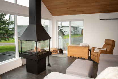 Modern living room with a Matte Black Don Bar 9200 series freestanding fireplace, wooden cabinet, and comfortable seating.