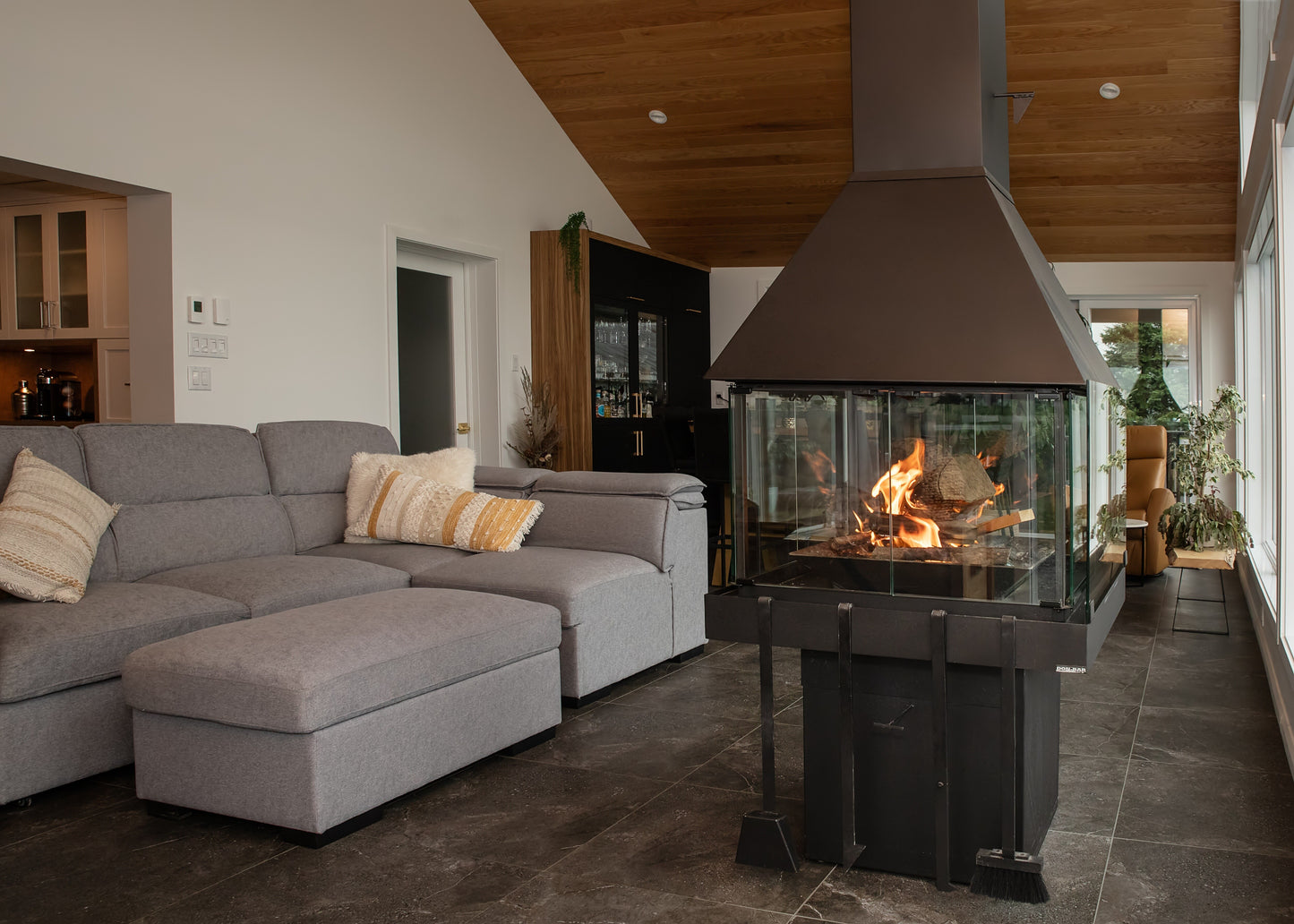 Modern living room with a gray sectional sofa and a freestanding Matte Black Don Bar 9200 series fireplace