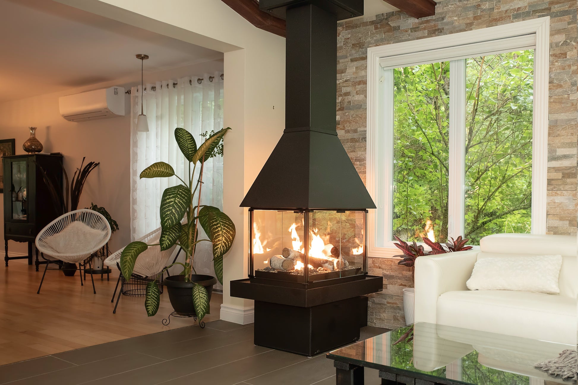 Matte Black Don bar 9200 series in a Modern living room with a black Chimney connected to the ceiling and a view of trees outside.