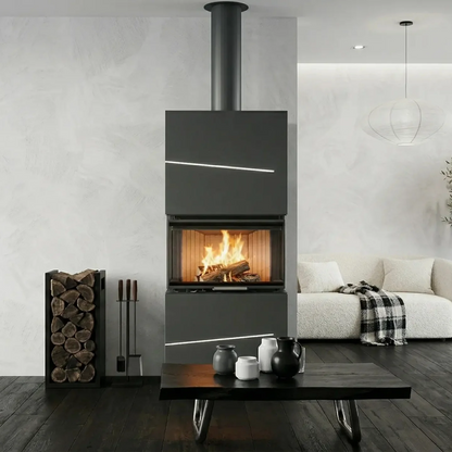 Black freestanding Albero AL9C three sided wood fireplace with visible flame view from a panoramic glass standing beside a flower in a modern living room. Eco Design Fireplace, Modern Indoor Fireplace. This fireplace is similar to A.Caminetti Crystal 80 3D Wood Burning Fireplace with 3 Glass Sides, Crystal 110 Max Wood-Burning Fireplace A.Caminetti 3 Glass Sides, Three Sided 75, Kratki – Inga Freestanding 3 sided Fireplace., Dorako ECO MAX 7 3F 3 Sided Glass Wood Stove: Handmade Wall-Insert Glass Fireplace.