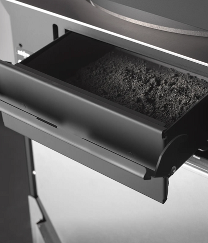 Black Close up view of Ash pan of free standing Stuv S-P10 pellet stove with visible burning flame in a modern living room. Modern Indoor remote control and Smart phone control Home heating fireplace. Eco-Friendly, Gentle flame Indoor fireplace. This Fireplace is similar to ComfortBilt Alpine HP40 Pellet Stove, Osburn Volta Pellet Stove, Quadra-Fire Outfitter II Pellet Stove Display Demo,US Stove 1300 Sq ft Wood Pellet Stove, Castle | Serenity Pellet Stove.