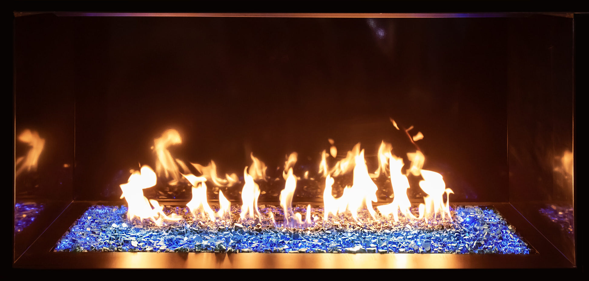 Up close view of Contemporary Gas Glass Fireplace with flames burning in a dark setting