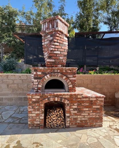 Brick outdoor Wood-fired pizza oven DIY KIT with wood storage on a patio outdoor kitchen setup ready to make your perfect outdoor kitchen. CBO 1000 wood fired Pizza Oven, natural gas pizza oven, DIY pizza oven kit, residential countertop pizza oven, Chicago Brick Oven, backyard pizza oven, outdoor kitchen pizza oven, hybrid pizza oven for home. Alfa Pizza Oven 3 pizze but better made in America, Wood Burning oven -Ooni Gozney.