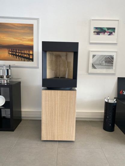 Bleach oak base free standing Stuv S-P10 pellet stove in a modern living room. Modern Indoor remote control and Smart phone control Home heating fireplace. Eco-Friendly, Gentle flame Indoor fireplace. This Fireplace is similar to ComfortBilt Alpine HP40 Pellet Stove, Osburn Volta Pellet Stove, Quadra-Fire Outfitter II Pellet Stove Display Demo,US Stove 1300 Sq ft Wood Pellet Stove, Castle | Serenity Pellet Stove.