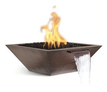A hammered copper fire and water bowl with a distinctive geometric design, showcasing a bright flame and a clear stream of water pouring from a side spout