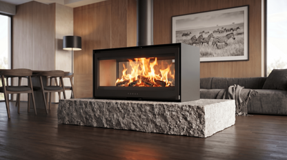 Forge D120 Freestanding double sided wood burning modern indoor fireplace with a visible wood burning flame in a modern living room. MCM fireplace, double door fireplace, See through Fireplace, Eco-friendly fireplace with chimney system. This product is similar to Stuv 21 - 85DF Double Sided Built-In Wood Burning Fireplace with Glass Door, Steel Frame, Stuv 21-95 Double sided Wood Stove with Retractable Glass Door, 48″ Artisan Double-Sided Vent Free Linear Fireplace, IFT 2.0.