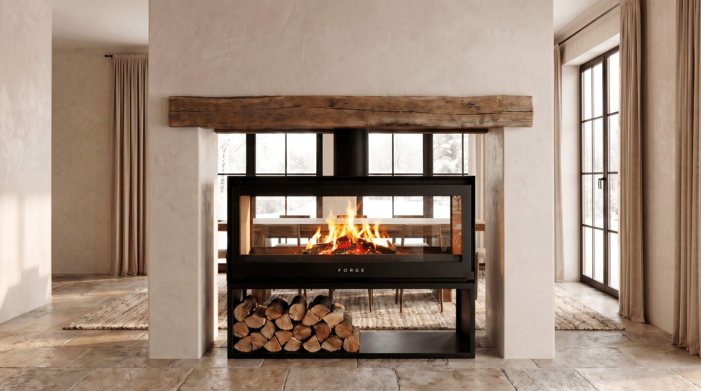 Forge D120 Freestanding double sided wood burning fireplace with matching woodbox base with logs of wood and a visible wood burning flame in a modern living room. MCM fireplace, double door fireplace, See through Fireplace, Eco-friendly fireplace with chimney system. This product is similar to Stuv 21 - 85DF Double Sided Built-In Wood Burning Fireplace with Glass Door, Steel Frame, Stuv 21-95 Double sided Wood Stove with Retractable Glass Door, 48″ Artisan Double-Sided Vent Free Linear Fireplace, IFT 2.0.