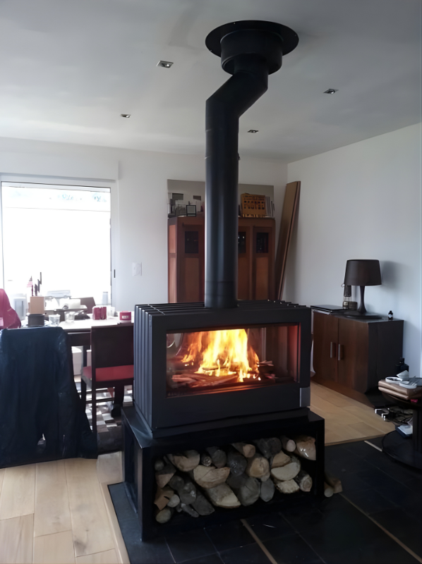 Invicta Aaron Double Sided Glass 36" Cast Iron Stove sitting on a small bench and a logs under the bench in a middle of living room.