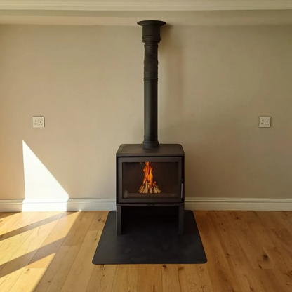Black Dorako STO M14 Wood-burning stove with a chimney with Visible flame in a room with wooden flooring and beige walls. 100,000 BTUs with A+ energy efficiency class