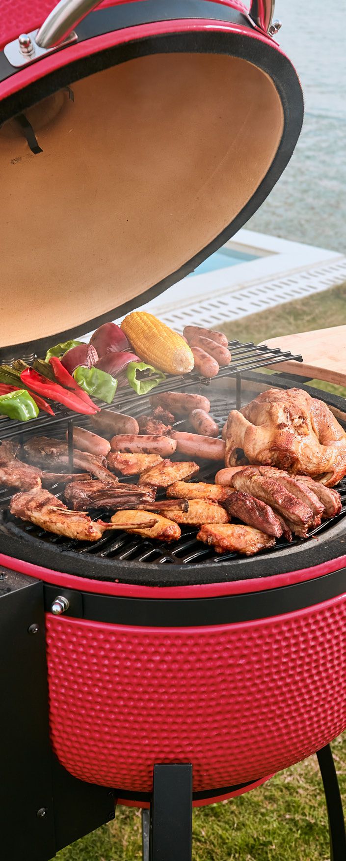 Red barbecue grill with food on a grassy area Smoker Pellet grill green egg style back patio camping grill
best pellet grill under $1000 
pellet grill clearance sale
best portable pellet grill for camping
and patio 
heavy duty stainless steel pellet grill
best pellet smoker for beginners
built-in pellet grill for outdoor kitchen