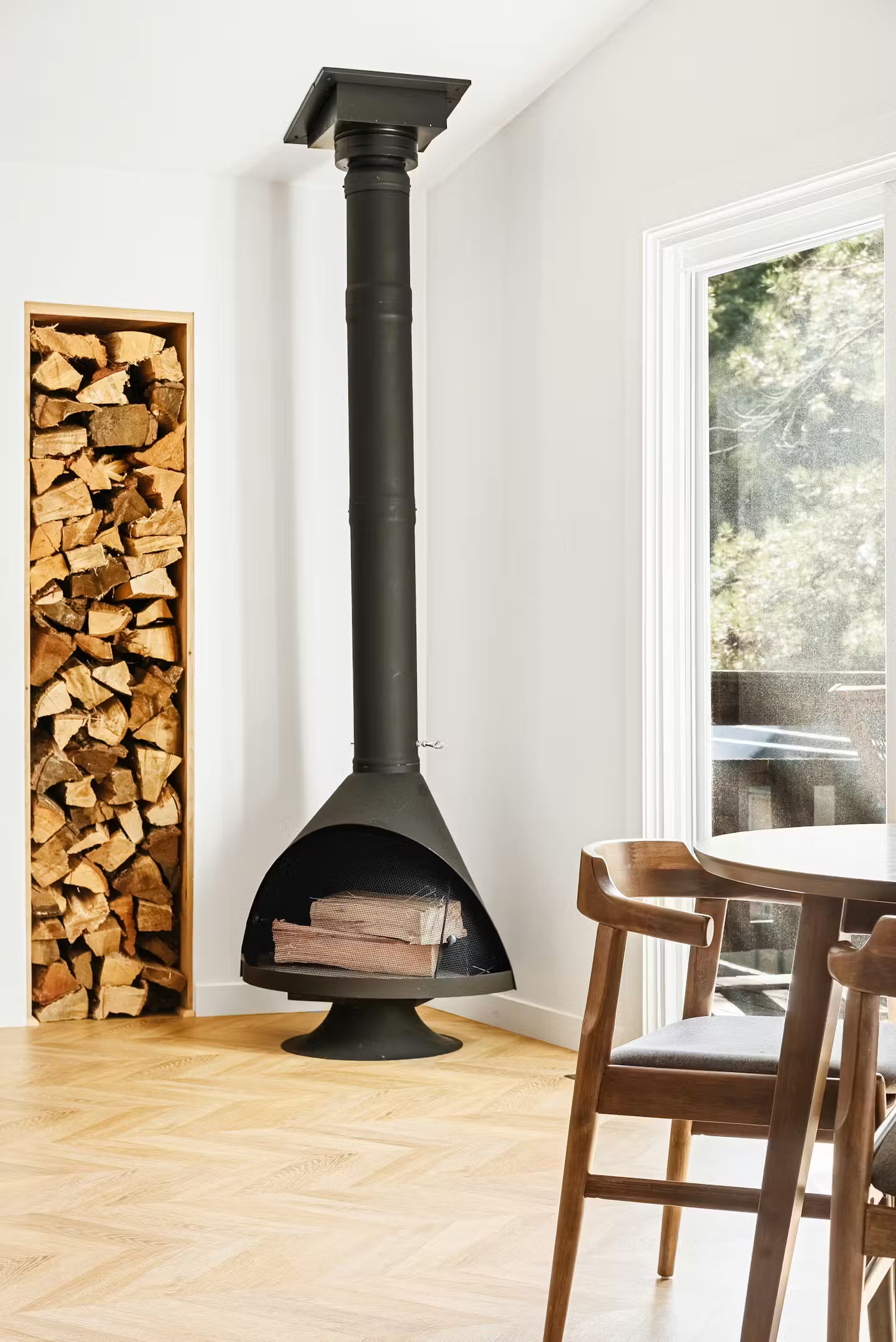 Matte Black top finish and matching Base Malm 30" zircon Wood burning fireplace in Modern living room with logs stack and table. 