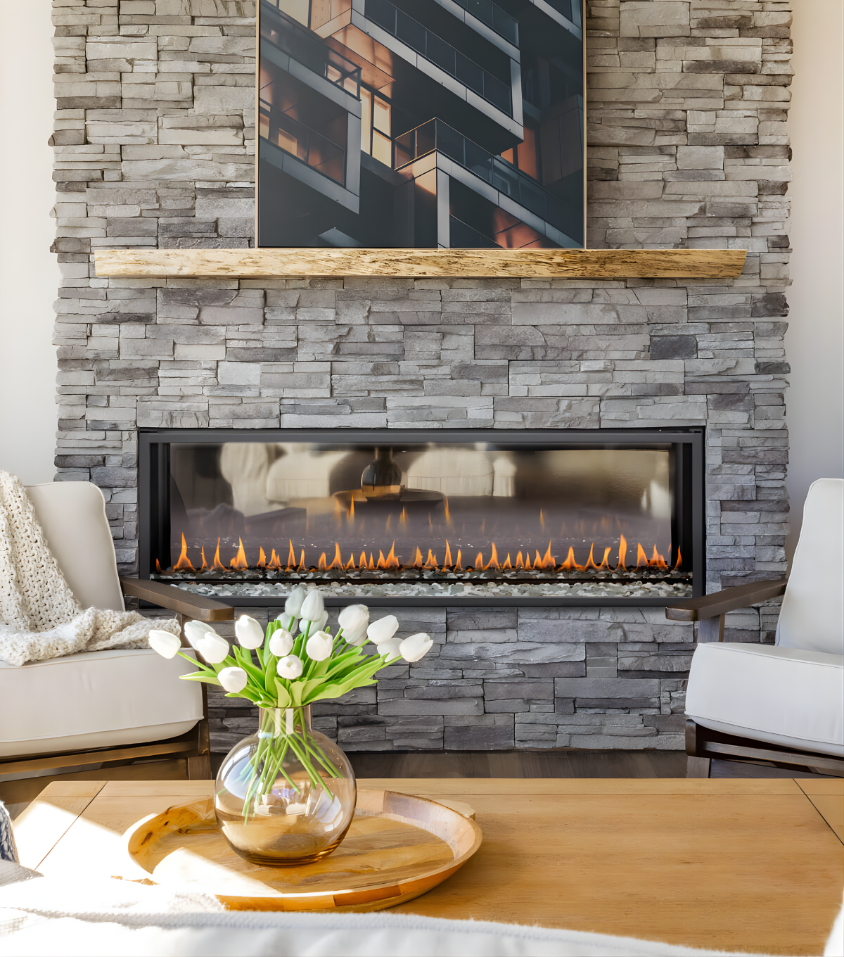 Built-In See Through Montigo Exemplar Gas Fireplace Inserts into a stone brick wall with visible flame and Wooden Mantel and Artwork above the fireplace  in a modern living room. Gas Burning Double sided Fireplace
Create a modern look with one of our many exquisite Direct Vent Model linear gas fireplaces. This Eco-friendly Montigo Exemplar is similar to 48" Isokern Maximus Linear Gas Fireplace, Napoleon Clearion Elite See-Through Fireplace, Empire 48" Boulevard Direct Vent See-Through Linear Gas Fireplace.