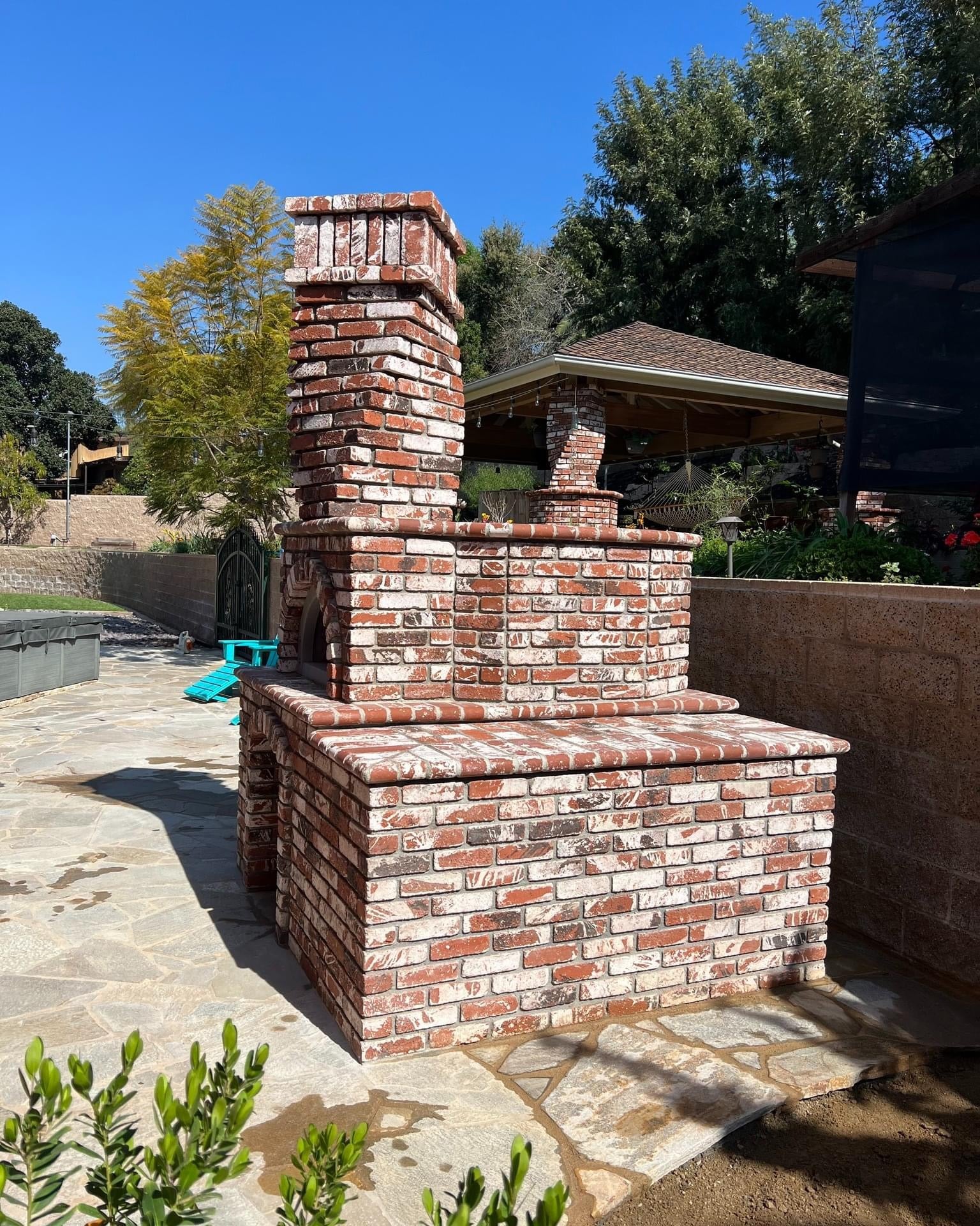 Brick outdoor Wood-fired pizza oven DIY KIT with wood storage on a patio outdoor kitchen setup ready to make your perfect outdoor kitchen. CBO 1000 wood fired Pizza Oven, natural gas pizza oven, DIY pizza oven kit, residential countertop pizza oven, Chicago Brick Oven, backyard pizza oven, outdoor kitchen pizza oven, hybrid pizza oven for home. Alfa Pizza Oven 3 pizze but better made in America, Wood Burning oven -Ooni Gozney.