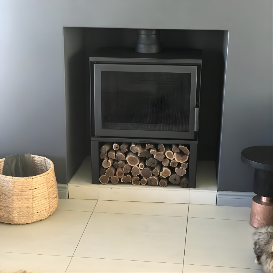 Scandinavian style Black Dorako STO M14 Wood-burning stove with logs under in a room with neutral colors. 100,000 BTUs fireplace with A+ energy efficiency class STUV Cube Style fireplace