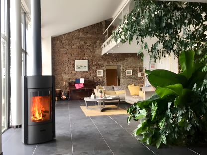 Modern living room with a wood Burning STUV 30 C Fireplace, sofa, and decorative elements.