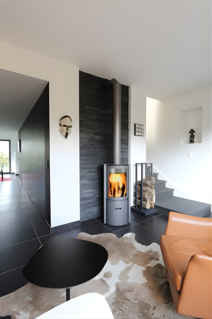 Stuv 30C wood burning fireplace with a small log rack in a modern living room with leather sofa, and black table.