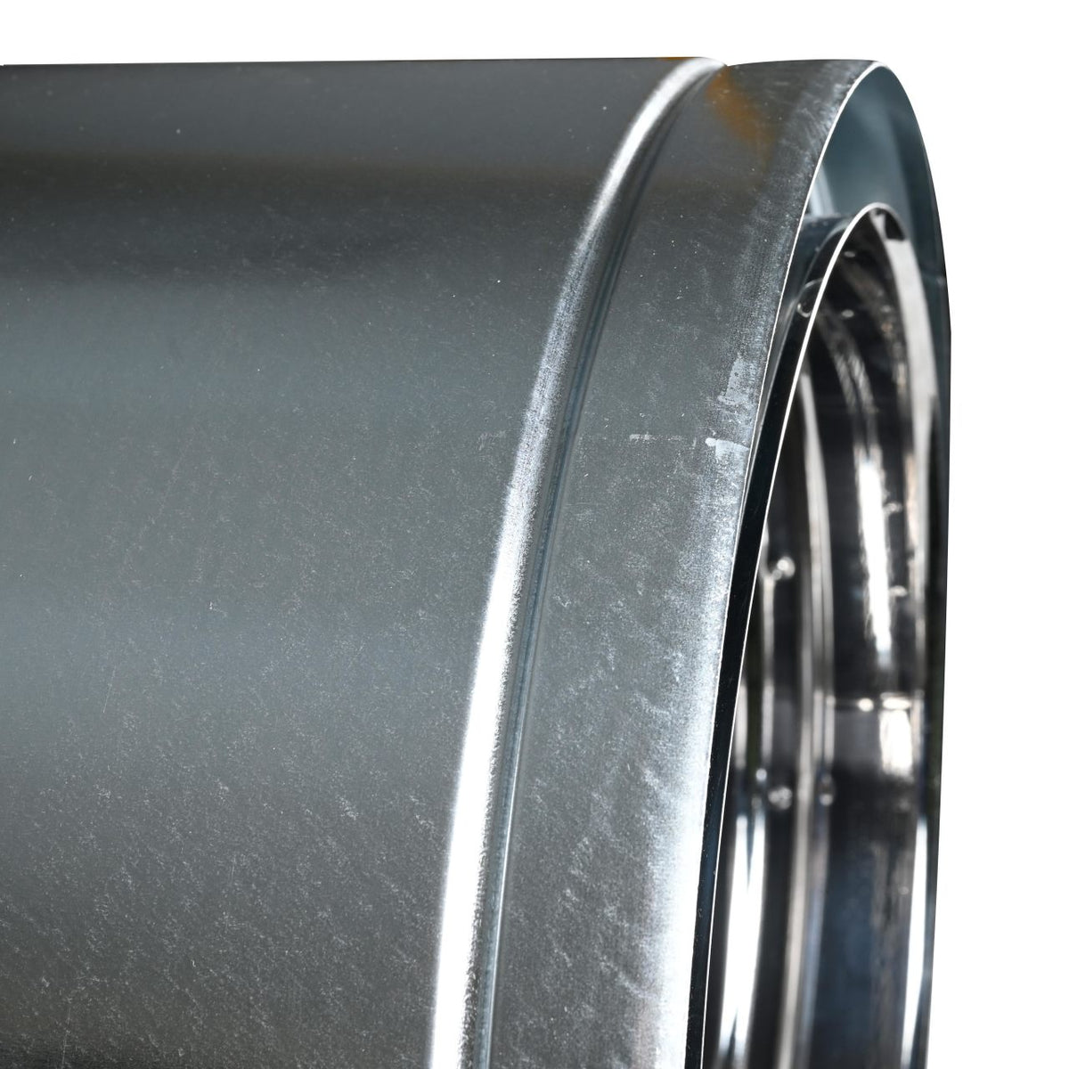 Side close-up view of stainless steel duratech II chimney pipe showing a circular opening at the side with metal wall. Exceptional factory-built all-fuel chimney pipe, lightweight design, double-wall, air-cooled chimney system for use with masonry fireplaces which burn wood, oil, coal, or gas.