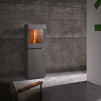 Steel Base free standing Stuv S-P10 pellet stove with visible burning flame in a modern living room. Modern Indoor remote control and Smart phone control Home heating fireplace. Eco-Friendly, Gentle flame Indoor fireplace. This Fireplace is similar to ComfortBilt Alpine HP40 Pellet Stove, Osburn Volta Pellet Stove, Quadra-Fire Outfitter II Pellet Stove Display Demo,US Stove 1300 Sq ft Wood Pellet Stove, Castle | Serenity Pellet Stove.