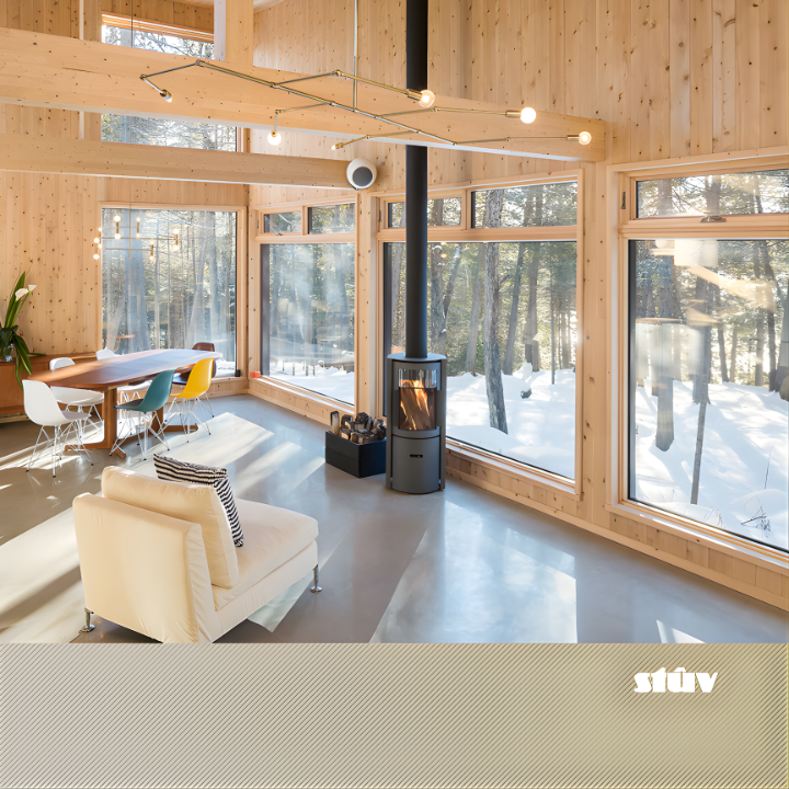 Freestanding Modern Grey Stuv 30C wood burning stove with Chimney extension to the roof in a Modern living room with wooden interior, large windows, and a snowy outdoor view. Premium and compact Indoor log burner fireplace with high-quality steel construction, Multi-Use Function and wide range BTU heat Output. 
Reduce carbon footprint with Stuv 30C wood stove from Smokey Mountain Fireplace, Eco-friendly and Best for the money fireplace.