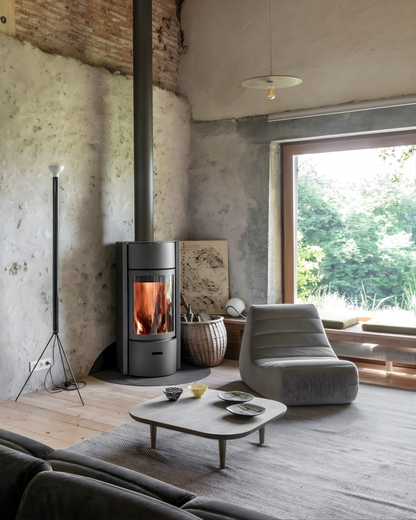 Grey Stuv 30C wood burning stove positioned in a corner of a living room with chimney extension to the roof and a gray armchair, wooden table at the center and large glass window . Product Title: Stûv 30-Compact | High-Efficiency Wood Burning Stove | Japandi Design

Meta Description: Elevate your home with the Stûv 30-C. A carbon-neutral, high-efficiency fireplace insert for 2026. Featuring 360° rotation and a minimalist Japandi aesthetic.

URL Handle: /products/stuv-30-compact-wood-burning-stove-japandi