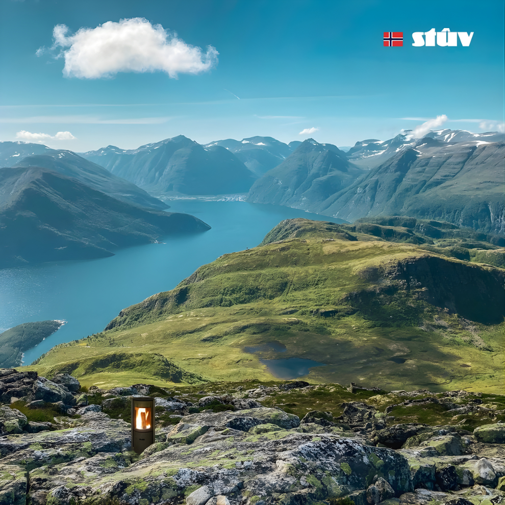 Scenic view of mountains and a lake with a visible flame of Stuv 30C on a rock in the foreground.