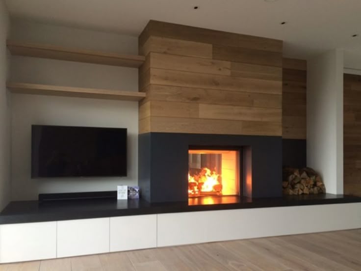 Modern living room view of Thin edge frame Stuv 21-95DF with grey front panel and stack of logs beside the fireplace