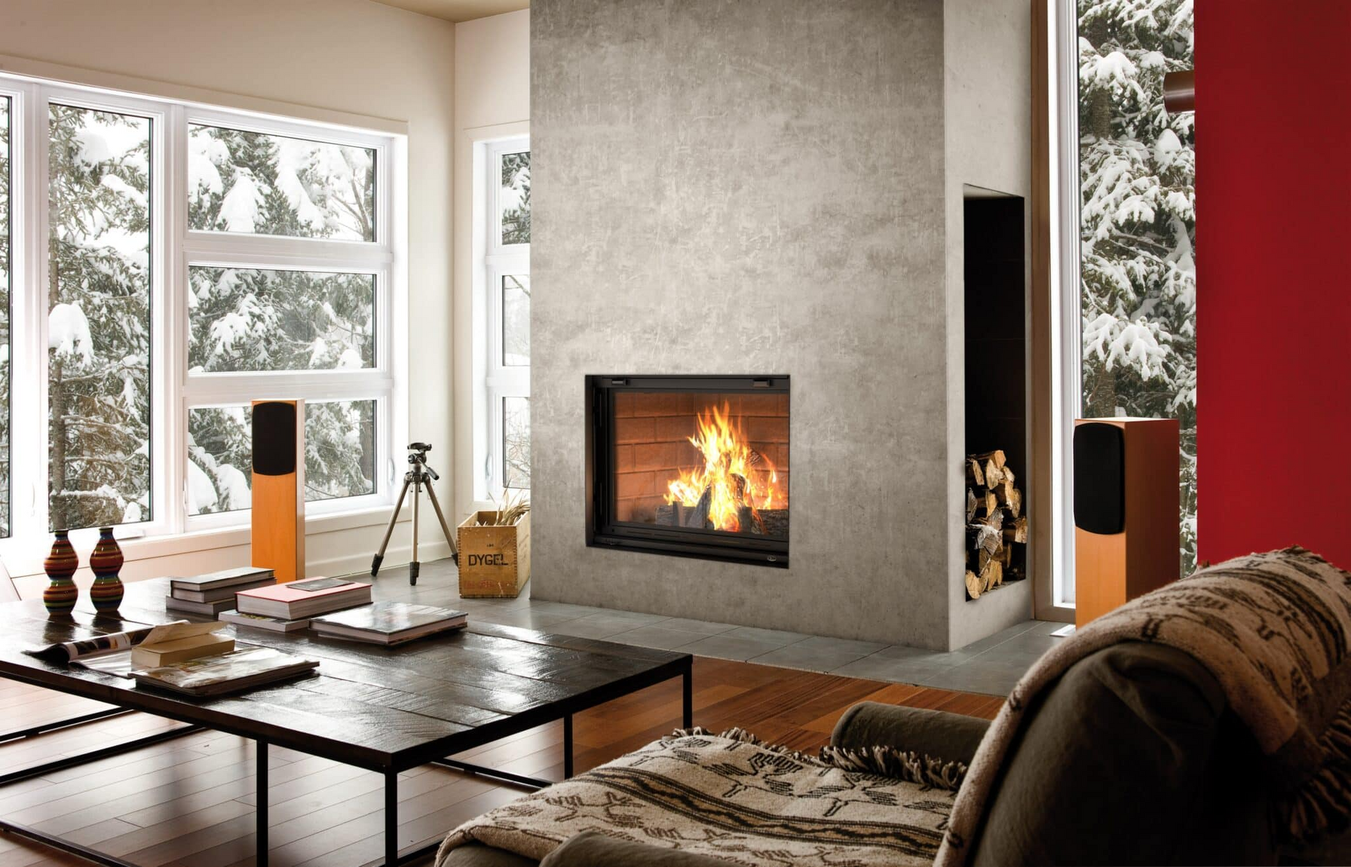 Valcourt Antoinette Black Built-in indoor wood burning fireplace with mansory trim, guillotine-style door and visible wood burning flame in a modern living room. Heating area up to 1,000 sq. ft, EPA qualified. Antoinette Modern hearth fireplace is similar to Majestic Biltmore Wood Burning Fireplace - 50", Supreme Astra Single-Sided Wood Burning Fireplace, Empire Aspen Traditional Wood Burning Fireplace, Montigo Divine Bay H38DFPRC Direct Vent Gas Fireplace.