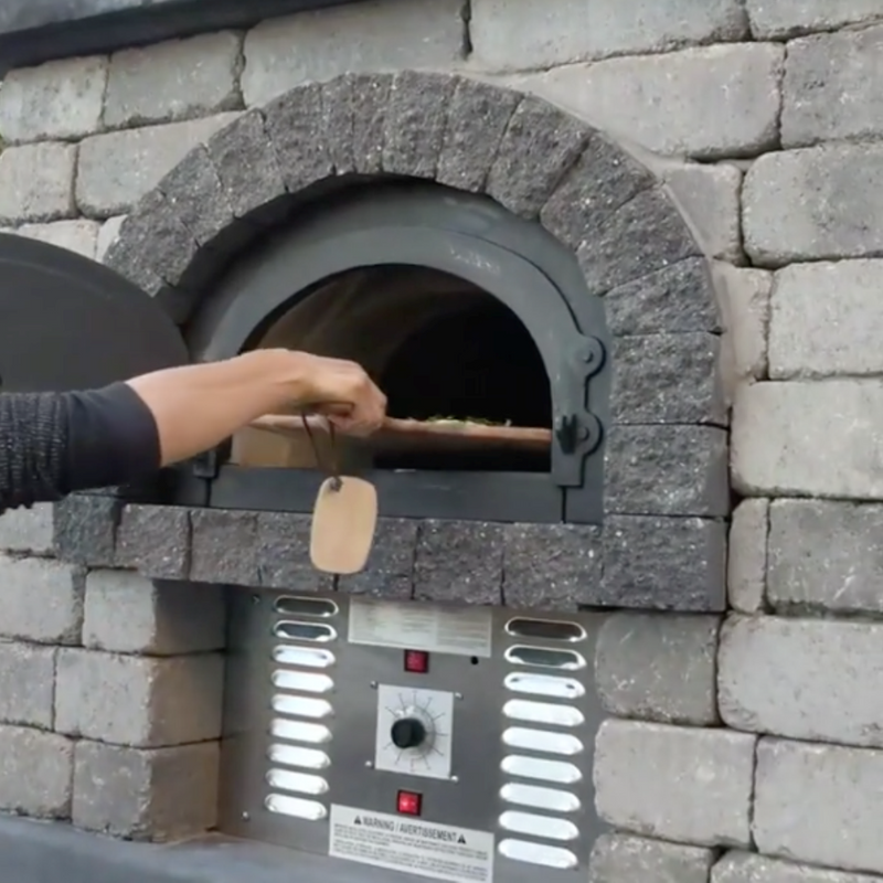 Brick outdoor Wood Gas Hybrid pizza oven with wood storage on a patio outdoor kitchen setup ready to make your perfect outdoor kitchen. CBO 750 Hybrid Pizza Oven, dual fuel pizza oven, outdoor wood fired pizza oven, natural gas pizza oven, DIY pizza oven kit, residential countertop pizza oven, Chicago Brick Oven, backyard pizza oven, outdoor kitchen pizza oven, hybrid pizza oven for home. Alfa Pizza Oven 3 pizze but better made in America  with built in Gas BBQ LPG NG Pizza Oven Wood Burning Ooni Gozney
