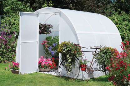 Exterior view of 8' X 8' early bloomer greenhouse kit with flowers and plants arranged inside the greenhouse and plants and flowers hung on a bicycle outside the small greenhouse