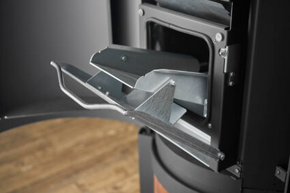 Hopper for loading pellets into Matte Black Stûv P-20S Freestanding Modern Indoor pellet burning stove in large close spade with visible burning flame and pellet twin set container beside the fireplace. Elegance,silence, performance, ease of use and maintenance Fireplace. This pellet stove is similar to Stûv 30 Wood Stove | Compact Glass Fire Screen Stove | 360° Adjustable Rotating Wood Burning Stove With Double Walls, Osburn Aduro H1 Pellet/Wood Combo Hybrid Free Standing Stove SF00401, Comfortbilt Pellet.