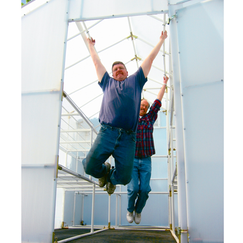 Two man hanging on the upper support frame of the solexx gardener's oasis greenhouse