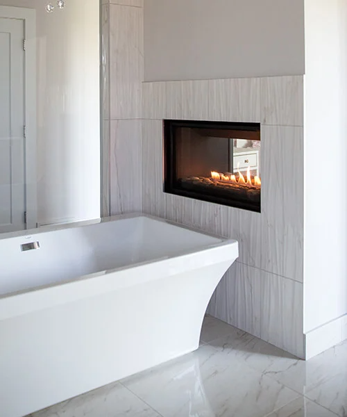 Built-In see Through Montigo Phenom Indoor Gas fireplace inserts into a wall in a modern bathroom with a bathub. Direct vent Modern Eco friendly Modern Fireplace.
The Artisan See-Through gas fireplace upgrades two spaces at once, easily and affordably, with the ambiance of a modern operation.
This product is similar to Napoleon High Definition Direct vent gas fireplace, Napoleon High Definition,  Invicta Aaron See Through woodstove, Modern Flames Orion, Heat & Glo escape series See Through Fireplace.