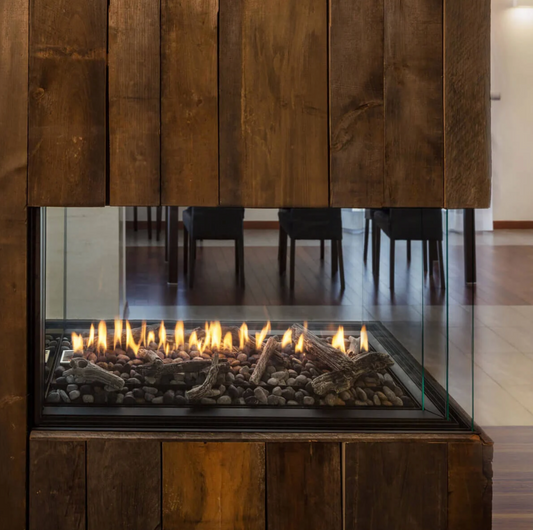 Built-In 3 Sided Montigo Exemplar RP424 See Through Gas Fireplace inserts in a wooden panel with a visible burning media in a modern living room. Direct Vent Indoor Natural gas and propane Fireplace perfect to connect your spaces, room to room or outdoor to indoor. 
High efficient and modern design Linear fireplace.