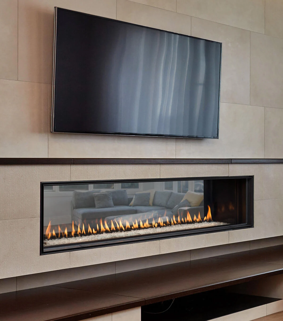 Montigo Distinction Linear Gas Fireplace Inserts into a Wall that connects the living room with Outdoor space with wall mounted television above the fireplace. Indoor Eco-friendly direct vent fireplace suitable for homes and commercial space.