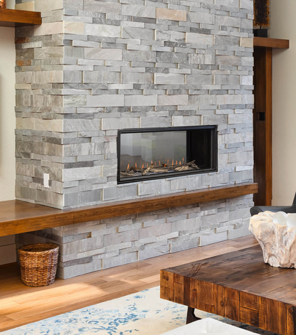 Montigo Distinction See Through Double Sided Gas Fireplace Insert in a Stone wall with Wooden Mantel. Indoor Built-in Linear Fireplace that connects space together to Uplifts your residence and commercial space.