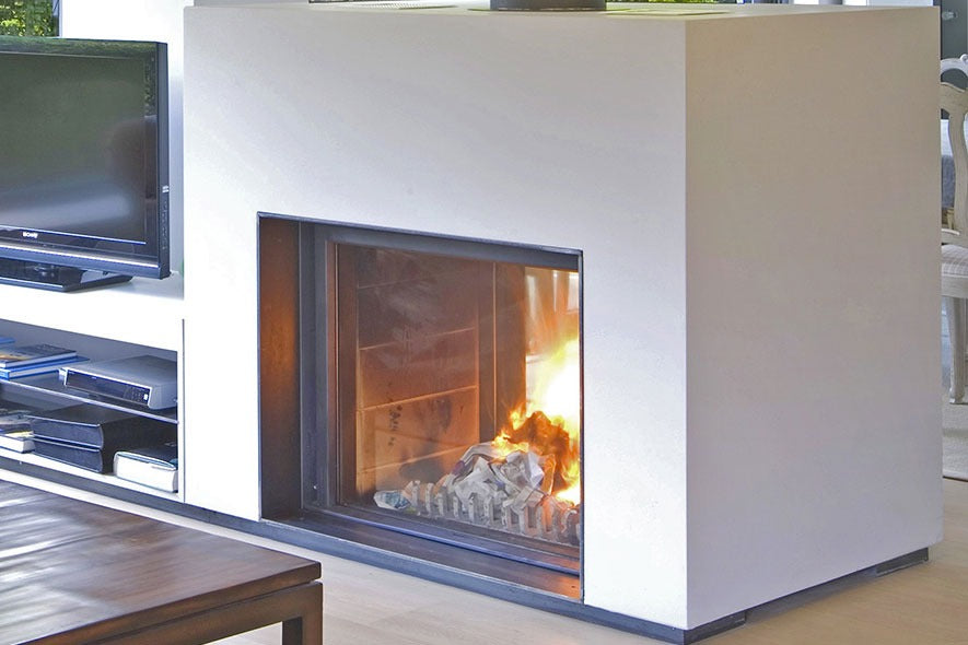 Modern fireplace Stuv 21-95 Double sided wood burning stove with white Front panel with glass door in a living room setting
