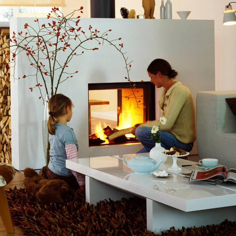 Two people sitting by the flame of Stuv 21-95 DF with thin edge frame and a white front panel in a cozy living room 