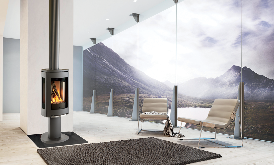Matte Black Freestanding Jotul GF 370 DV Gas Stove with three sided flame view and a direct vent to the room in a Modern living room with a  scenic mountain view 
