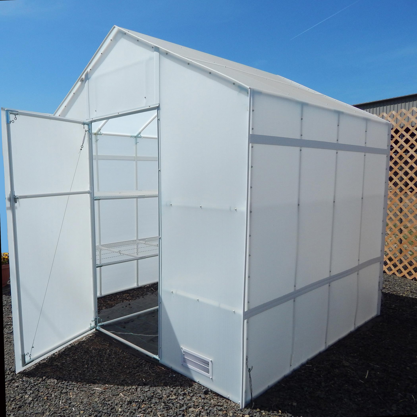 Outside view of 8' X 16' solexx garden master Small backyard greenhouse with open closeable door