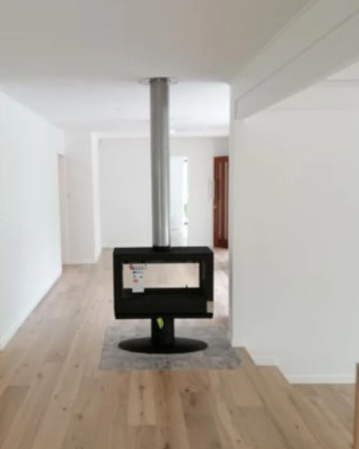 Actual image from our customer for middle of living room wood stove with Flue. Open space fireplace with a small hearth. you can heat your entire living area easily